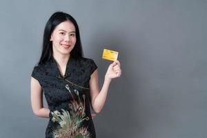 Asian woman wear Chinese traditional dress with hand holding credit card photo