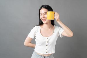 Young Asian woman with happy face and hand holding coffee cup photo