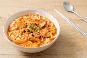 Korean udon ramen noodles with pork in kimchi soup photo