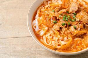 Korean udon ramen noodles with pork in kimchi soup photo