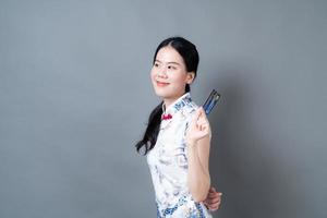 Mujer asiática vistiendo traje tradicional chino con la mano que sostiene la tarjeta de crédito foto