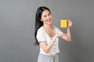 Young Asian woman with happy face and hand holding coffee cup photo