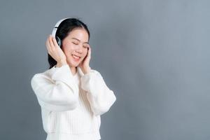 Young Asian woman listening to music with headphones photo