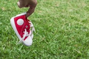 Cute red small canvas shoes on the grass photo