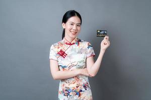 Asian woman wear Chinese traditional dress with hand holding credit card photo