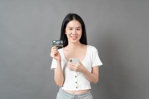 Asian woman with happy face and presenting credit card in hand showing trust and confidence for making payment photo