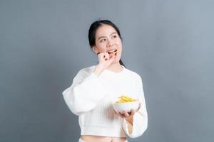 joven asiática comer papas fritas foto