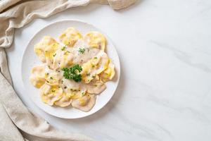 Ravioli pasta with mushroom cream sauce and cheese - Italian food style photo