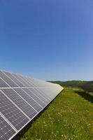 Estación de energía solar en la pradera de flores de verano foto