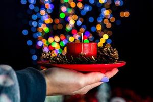 Holding Christmas decorated candle photo