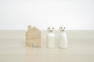 familia feliz y nuevo concepto de hogar. muñeca de madera de la familia en la mesa de madera. foto