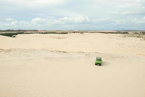 un coche en las dunas de arena blanca en muine, vietnam. foto