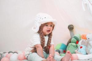 Little cute and adorable asian girl is playing with dolls in teepee tent. photo