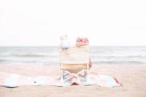 bebé sentado en la playa en un hermoso día de verano. foto