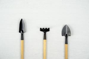 Garden shovel and fork on white background. Top view of various small gardening tools. photo