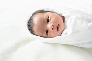 Newborn baby in white blanket. photo