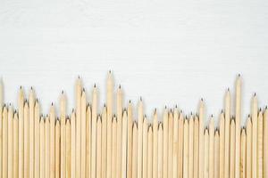 Arranged wooden pencils on white table. photo