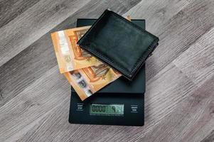 Billetes en euros en una escala con una cartera foto