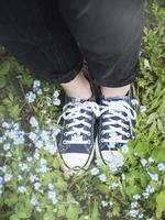 Legs in blue sneakers on the grass photo