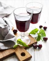 Cherry liqueur in a glass and fresh fruits photo
