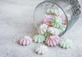 pequeños merengues blancos, rosas y verdes en el vaso