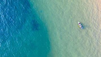 Aerial top view of kayaking around sea with shade emerald blue water and wave foam photo