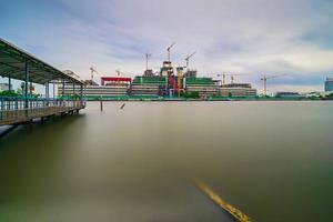 Building construction site and cranes beside the river, Long exposure photo