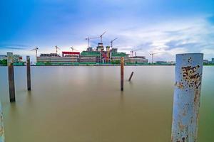 Building construction site and cranes beside the river, Long exposure photo