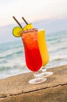 Iced cocktails drinking glass with sea and beach photo