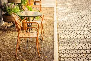 Silla vacía y mesa alrededor de cafetería y restaurante al aire libre foto