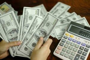 Businessmen women counting money on a stack of 100 US dollars banknotes photo