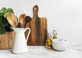 Kitchen utensils, tools and dishware on on the background white tile wall photo