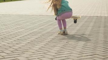ein kleines Mädchen fährt auf einem gelben Skateboard