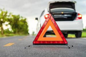 Problems car and a red triangle warning sign on the road photo