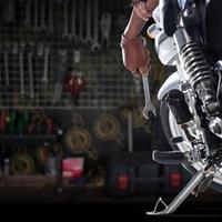 Cropped view of Mechanic using a wrench on a motorcycle photo