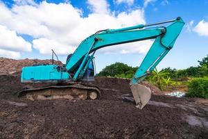 Excavadora en sitio de construcción bajo un cielo azul foto