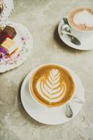White cup with latte coffee and cake photo