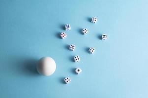 Minimal layout with a white egg and dice on blue background photo