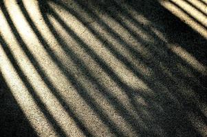 Bright sunlight and hard black shadows on the road. Shadow stripes on an asphalt road. photo