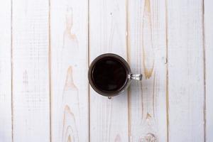 Coffee cup on white wooden table photo