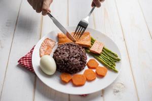 Health food concept, salmon with rice and vegetable on wood background photo