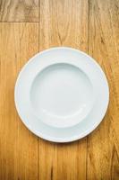 Empty white plate on wooden background photo