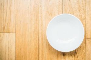 Empty white plate on wooden background photo