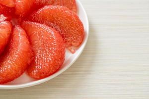 Fresh red pomelo fruit or grapefruit on plate photo