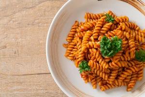 Spiral or spirali pasta with tomato sauce and sausage - Italian food style photo