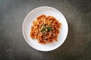 Spiral or spirali pasta with tomato sauce and sausage - Italian food style photo