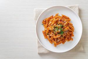 Spiral or spirali pasta with tomato sauce and sausage - Italian food style photo