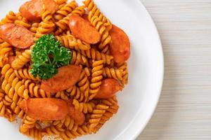 Spiral or spirali pasta with tomato sauce and sausage - Italian food style photo