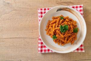 Spiral or spirali pasta with tomato sauce and sausage - Italian food style photo