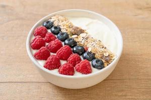 Homemade yogurt bowl with raspberry, blueberry, and granola  - healthy food style photo